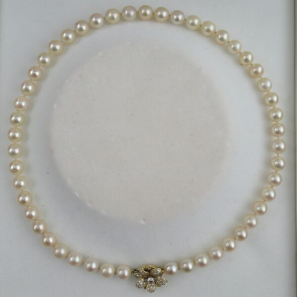 A vintage Cartier pearl necklace, with an 18k gold diamond set clasp
